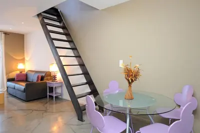 a living room with a glass table and pink chairs at Appartement du Tourisme in Zonza