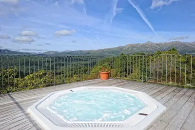 a hot tub sitting on top of a wooden deck at Appartement du Tourisme in Zonza