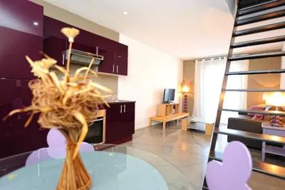 a living room with a glass table with a vase at Appartement du Tourisme in Zonza