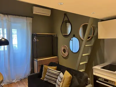 a living room with a couch and mirrors on the wall at Les Terrasses de Padoue in Corte