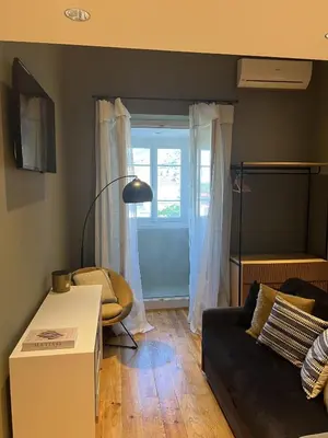 a living room with a black couch and a window at Les Terrasses de Padoue in Corte