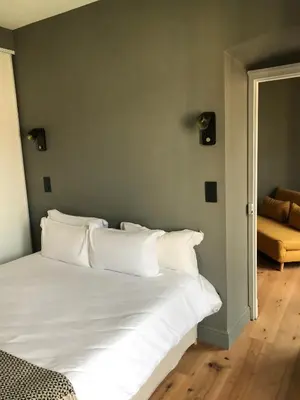 a bed with white pillows in a room at Les Terrasses de Padoue in Corte
