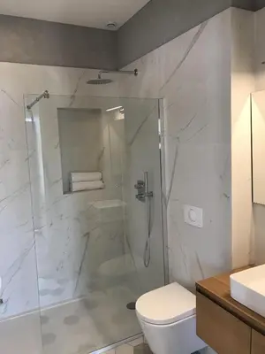 a bathroom with a shower with a toilet and a sink at Les Terrasses de Padoue in Corte