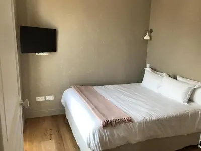a bedroom with a bed and a flat screen tv at Les Terrasses de Padoue in Corte