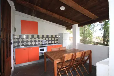 a kitchen with orange cabinets and a wooden table at Residence U Veniqui in Favone