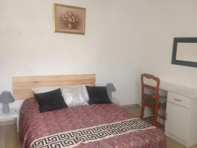 a bedroom with a bed and a desk and a chair at Gîte Emma in Santo-Pietro-di-Tenda