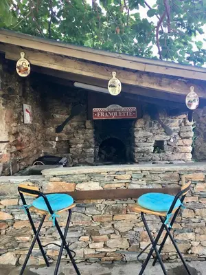 two chairs sitting in front of a stone fireplace at Gîte Emma in Santo-Pietro-di-Tenda