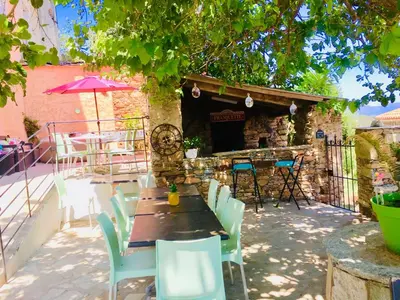 a patio with a table and chairs and a building at Gîte Emma in Santo-Pietro-di-Tenda