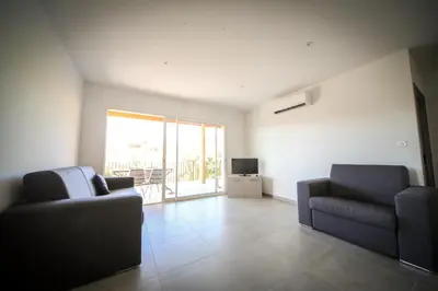 a living room with two couches and a television at SARL Valinco locations appartement 2 chambres in Olmeto