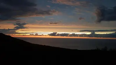 a sunset over a body of water with a hill at Villa Acqua Doria in Coti-Chiavari