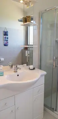 a white bathroom with a sink and a shower at Villa Acqua Doria in Coti-Chiavari