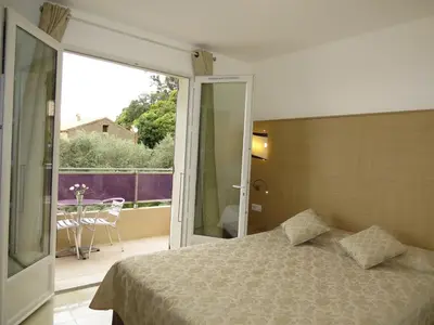 a bedroom with a bed and a balcony with a view at Hôtel Mare E Monti in Piana
