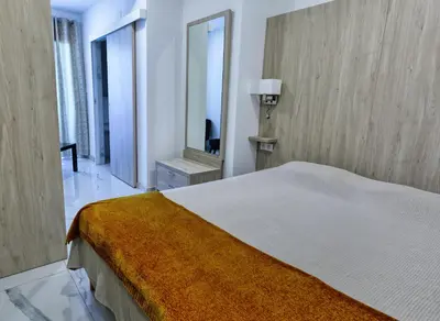 a bedroom with a large bed and a mirror at Hôtel Mare E Monti in Piana