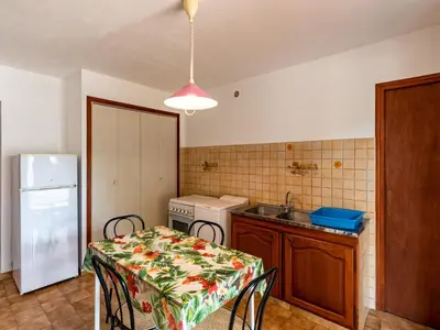 a kitchen with a table and a sink and a table and chairs at Apartment Dami II-1 by Interhome in Moriani Plage