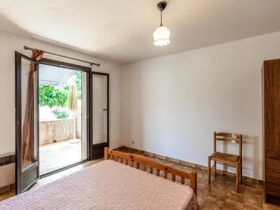 a bedroom with a bed and a sliding glass door at Apartment Dami II-1 by Interhome in Moriani Plage