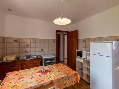 a kitchen with a refrigerator and a table in it at Apartment Dami II-2 by Interhome in Moriani Plage