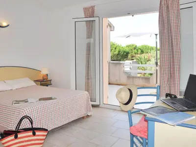 a bedroom with a bed and a desk with a laptop at Holiday Home Les Chênes by Interhome in Borgo