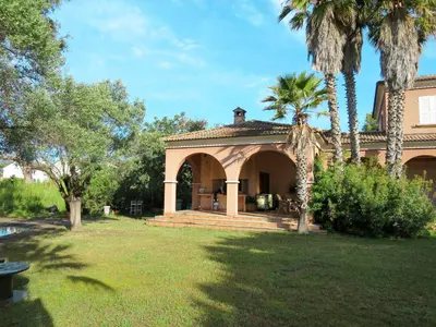 a house with a porch and a palm tree at Holiday Home Les Chênes by Interhome in Borgo