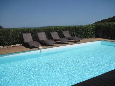 a group of chairs sitting next to a swimming pool at BENEDETU in Porto-Vecchio
