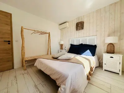 a bedroom with a large bed and a wooden floor at BENEDETU in Porto-Vecchio