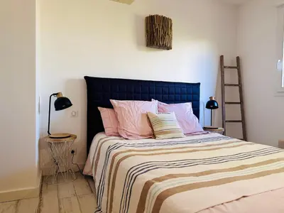 a bedroom with a large bed with pink pillows at BENEDETU in Porto-Vecchio