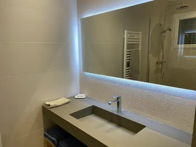a bathroom with a sink and a large mirror at BENEDETU in Porto-Vecchio