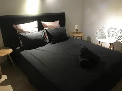 a bed with black sheets and pillows in a room at BENEDETU in Porto-Vecchio