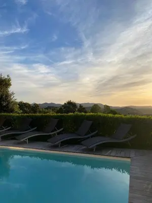 a row of lounge chairs next to a swimming pool at BENEDETU in Porto-Vecchio