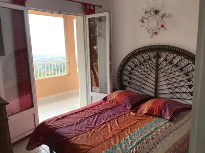 a bedroom with a bed and a window with a view at ELI&LOU avec piscine in Alata