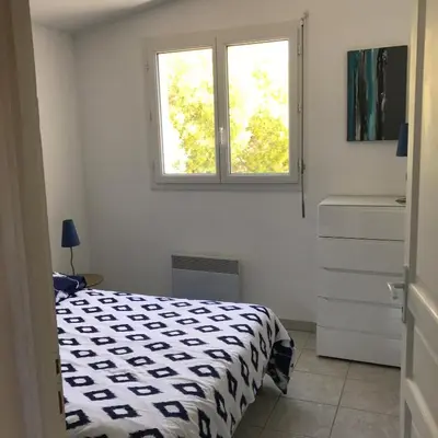a bedroom with a bed and a window at ELI&LOU avec piscine in Alata