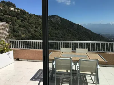 a table and chairs on a balcony with a view at ELI&LOU avec piscine in Alata