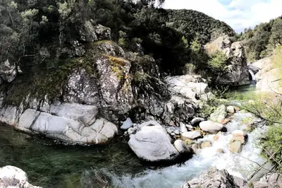 a stream of water with rocks in a river at Villa di Pardisoli in Prunelli-di-Fiumorbo