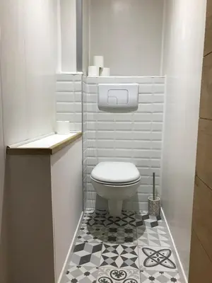 a bathroom with a toilet and a black and white tile floor at Studio plein centre ville in Ajaccio
