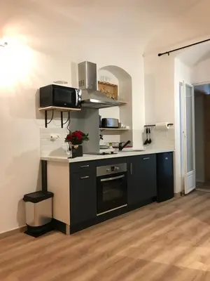 a kitchen with a black and white counter top at Studio plein centre ville in Ajaccio