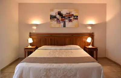 a bedroom with a bed with two lamps on both sides at Hôtel A casa di Maria Cicilia in Ghisonaccia