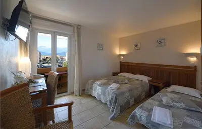 a hotel room with two beds and a window at Hôtel A casa di Maria Cicilia in Ghisonaccia