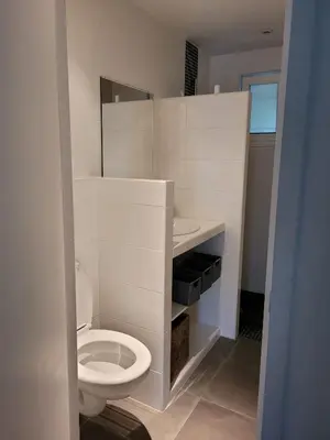 a white bathroom with a toilet and a sink at Mini villa au bord de la mer, proche Moriani (Corse) in Poggio-Mezzana