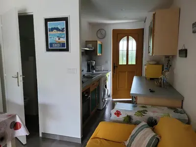 a kitchen with a yellow couch in a room at Mini villa au bord de la mer, proche Moriani (Corse) in Poggio-Mezzana