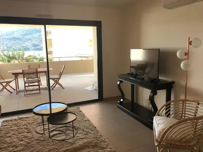 a living room with a tv and a table and chairs at Fronte di Mare in Propriano
