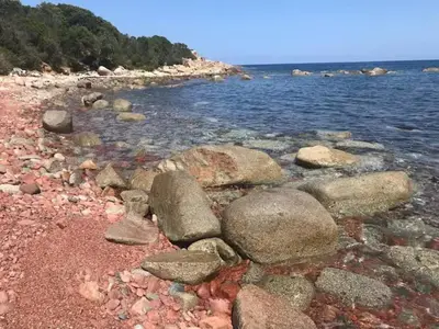 a group of rocks on a beach near the water at Villa Ucellu sur 600 m2 avec accès mer privilégié et piscine privée chauffée in Sainte-Lucie de Porto-Vecchio