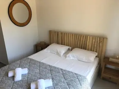 a bedroom with a bed with two white pillows and a mirror at Villa Ucellu sur 600 m2 avec accès mer privilégié et piscine privée chauffée in Sainte-Lucie de Porto-Vecchio