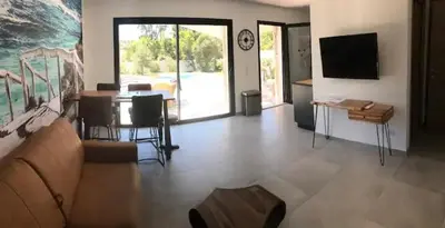 a living room with a couch and a table at Villa Ucellu sur 600 m2 avec accès mer privilégié et piscine privée chauffée in Sainte-Lucie de Porto-Vecchio
