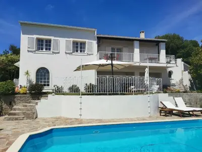 a villa with a swimming pool in front of a house at Villa Via serena in Ajaccio