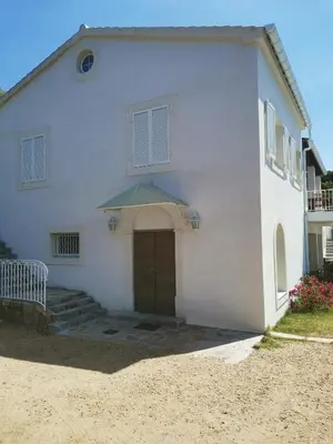 a white building with a large door and a porch at Villa Via serena in Ajaccio