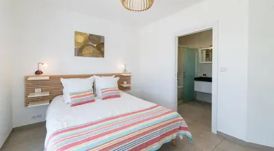 a bedroom with a bed with a striped blanket at Au Cœur de l'arrière pays DOMAINE A PRESA Villas avec Piscine Privée & chauffée in Matra
