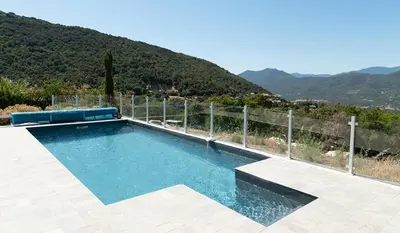a swimming pool with a fence and mountains in the background at Au Cœur de l'arrière pays DOMAINE A PRESA Villas avec Piscine Privée & chauffée in Matra