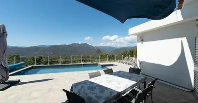 a patio with a table and a swimming pool at Au Cœur de l'arrière pays DOMAINE A PRESA Villas avec Piscine Privée & chauffée in Matra