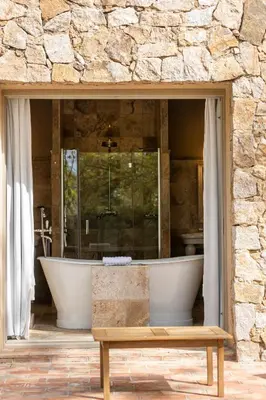 a large bathroom with a tub in a stone wall at La Signoria & Spa in Calvi