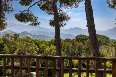 a view from the deck of a house with trees and mountains at La Signoria & Spa in Calvi