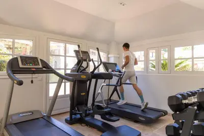 a woman running on a treadmill in a gym at La Signoria & Spa in Calvi